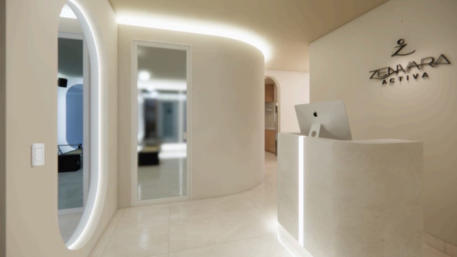 Recepción de Zenvara Activa: arco curvo iluminado, mostrador de microcemento y el logotipo del estudio en el muro
